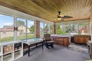 sunroom / solarium with wood ceiling, plenty of natural light, ceiling fan, and area for grilling