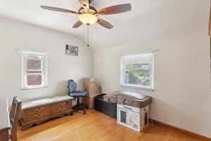 living area featuring light wood-type flooring, ceiling fan, and vaulted ceiling