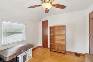 interior space featuring wood finished floors, ceiling fan, and baseboards