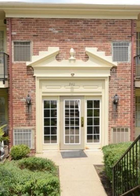 doorway to property with brick siding