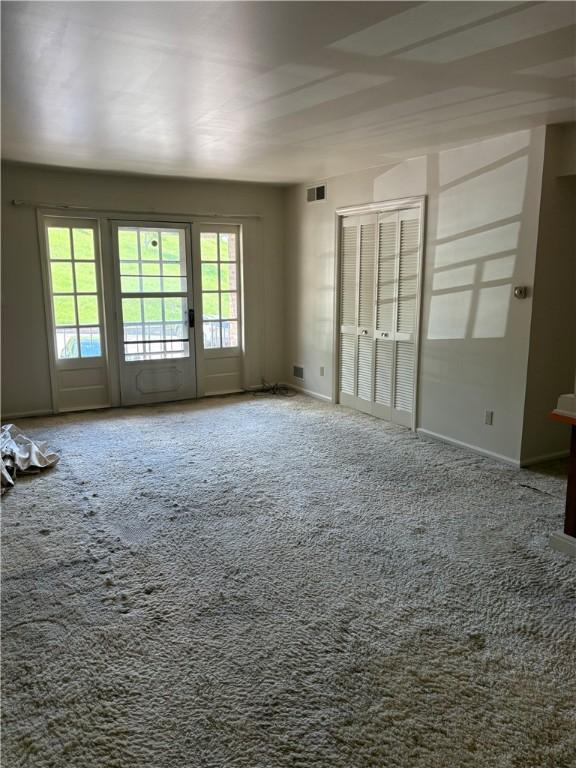 unfurnished room with carpet flooring and baseboards