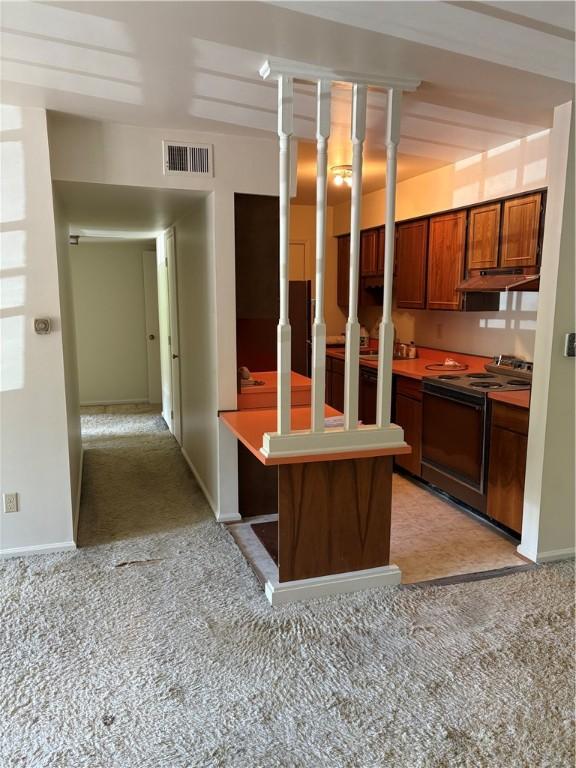 kitchen featuring black electric range oven, light colored carpet, and under cabinet range hood
