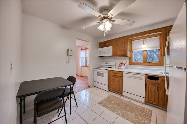 kitchen featuring white appliances, brown cabinets, ceiling fan, light countertops, and light tile patterned flooring