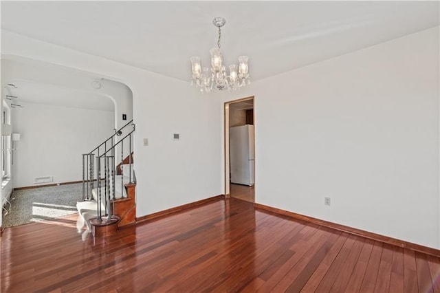 149 Fairfax Rd, Forest Hills Boro, PA 15221 - unfurnished room with baseboards, a chandelier, wood finished floors, stairs, and arched walkways