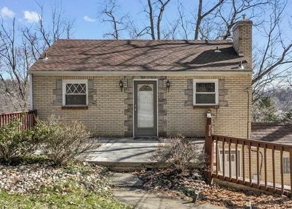 149 Fairfax Rd, Forest Hills Boro, PA 15221 - view of front of house featuring a chimney, brick siding, a shingled roof, and a deck