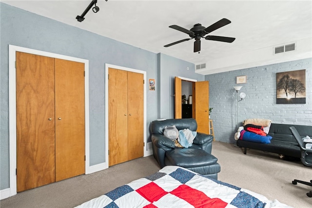 carpeted bedroom with two closets and ceiling fan