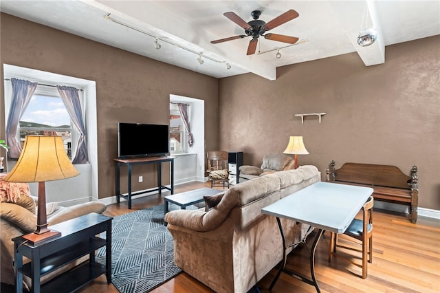 living room with track lighting, wood finished floors, a ceiling fan, and baseboards