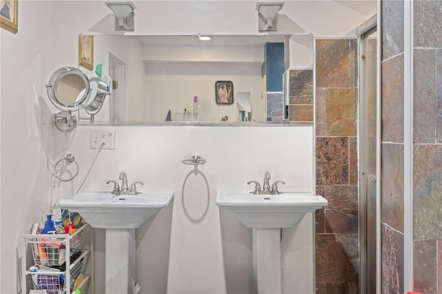 bathroom featuring tiled shower and a sink
