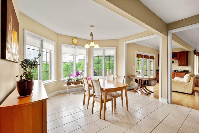 dining room featuring healthy amount of natural light, baseboards, a chandelier, and light tile patterned floors