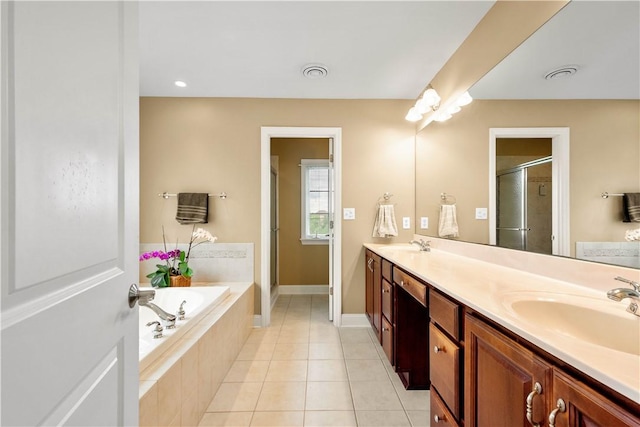 full bath with a stall shower, tile patterned floors, a garden tub, double vanity, and baseboards