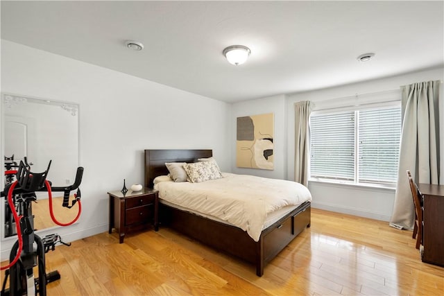 bedroom with light wood-type flooring and baseboards