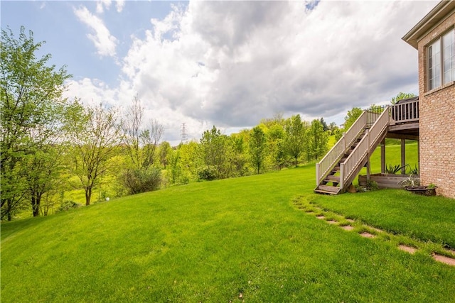 view of green lawn with stairs and a wooden deck