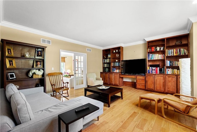living area featuring light wood-type flooring and crown molding