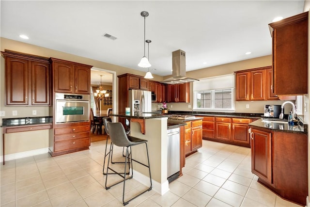kitchen with appliances with stainless steel finishes, a sink, island exhaust hood, a kitchen breakfast bar, and light tile patterned floors