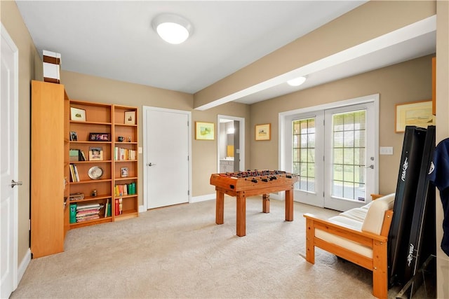 game room with light carpet and baseboards