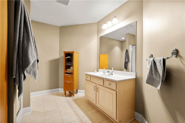 bathroom featuring vanity, tile patterned flooring, and baseboards