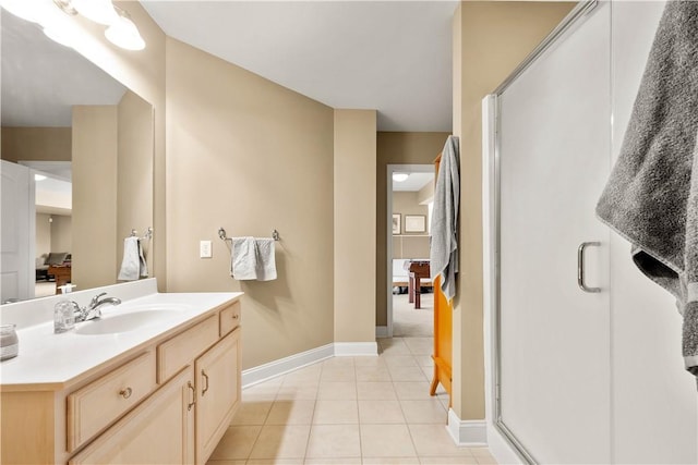 bathroom featuring tile patterned floors, a stall shower, baseboards, and vanity