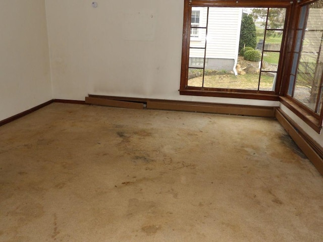 carpeted empty room with baseboards