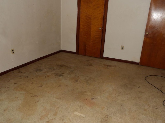 unfurnished bedroom featuring carpet floors and baseboards