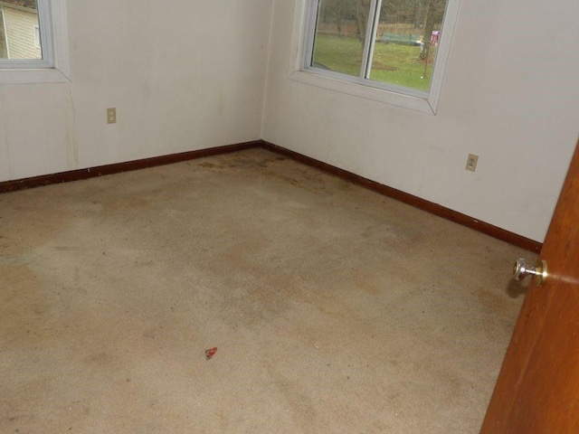 spare room featuring carpet floors and baseboards