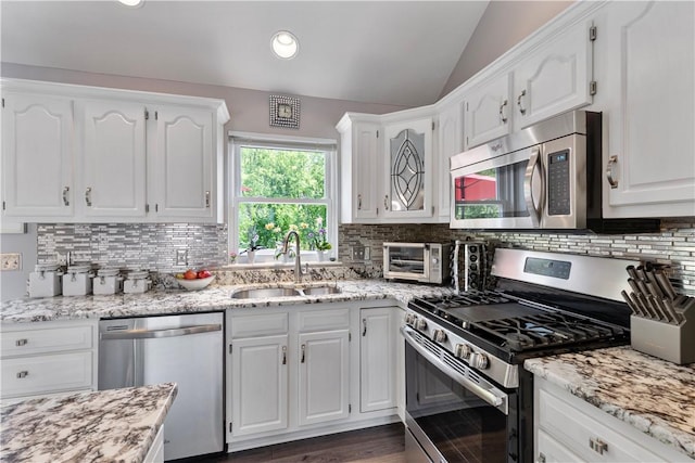 113 Seavey Highlands, Shaler, PA 15223 - kitchen featuring appliances with stainless steel finishes, a sink, lofted ceiling, white cabinets, and backsplash
