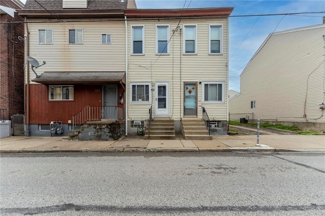 townhome / multi-family property featuring roof with shingles and entry steps
