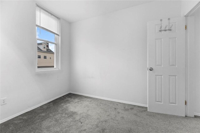 carpeted spare room featuring baseboards