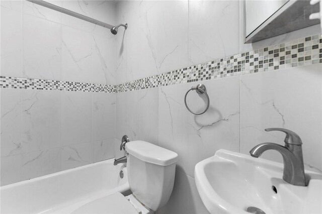 bathroom featuring a sink,  shower combination, and toilet