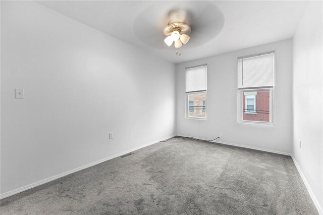 spare room with carpet flooring, ceiling fan, and baseboards