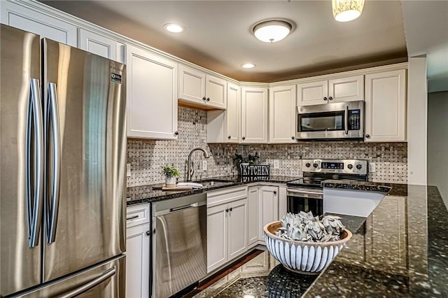 1611 Kenzie Dr, Robinson Twp Nwa, PA 15205 - kitchen with stainless steel appliances, a sink, white cabinets, dark stone counters, and backsplash