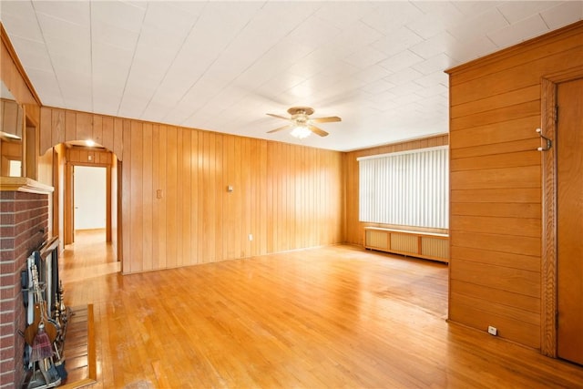 108 Gay St, Salisbury, PA 15558 - unfurnished living room with radiator heating unit, arched walkways, ceiling fan, a fireplace, and wood finished floors