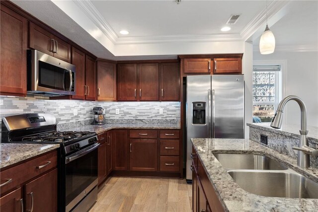 216 Settlers Ct, Peters Twp, PA 15367 - kitchen featuring appliances with stainless steel finishes, a sink, light wood-type flooring, tasteful backsplash, and decorative light fixtures