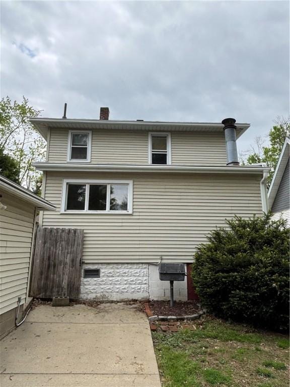 back of property featuring a patio, fence, a chimney, and crawl space
