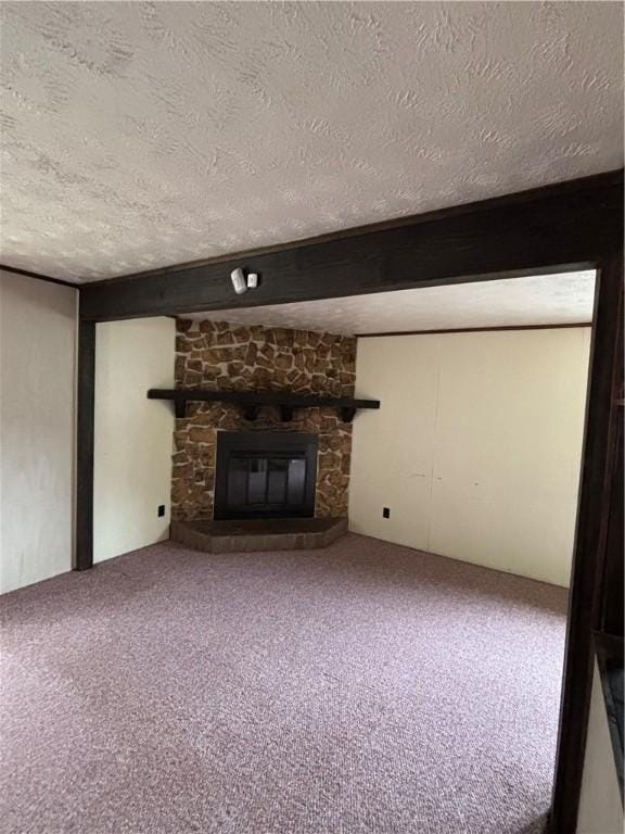 unfurnished living room with a textured ceiling, a fireplace, and carpet floors