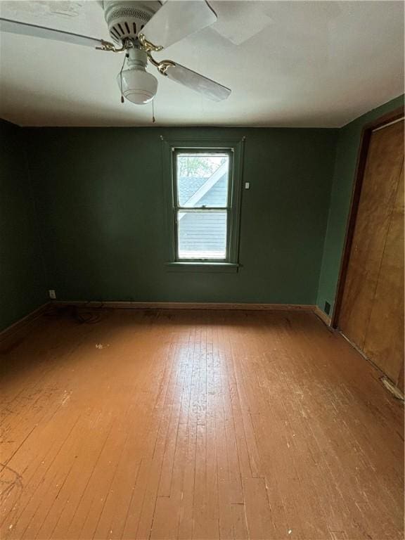 spare room featuring hardwood / wood-style flooring, baseboards, and a ceiling fan