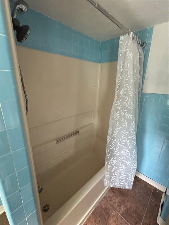 full bath with a shower with curtain and tile patterned floors