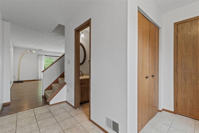 567 Brandywine Dr, Cranberry Twp, PA 16066 - corridor with light tile patterned floors, stairway, a textured ceiling, and baseboards