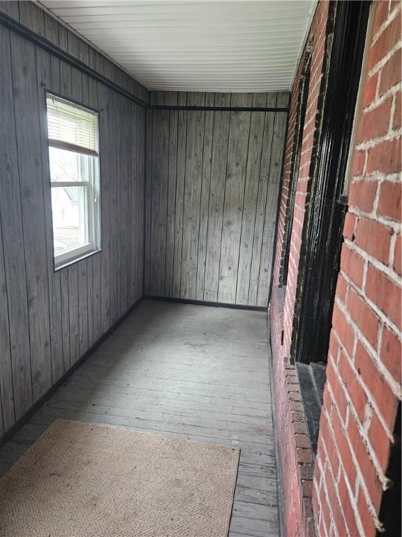 empty room featuring wood-type flooring and wooden walls