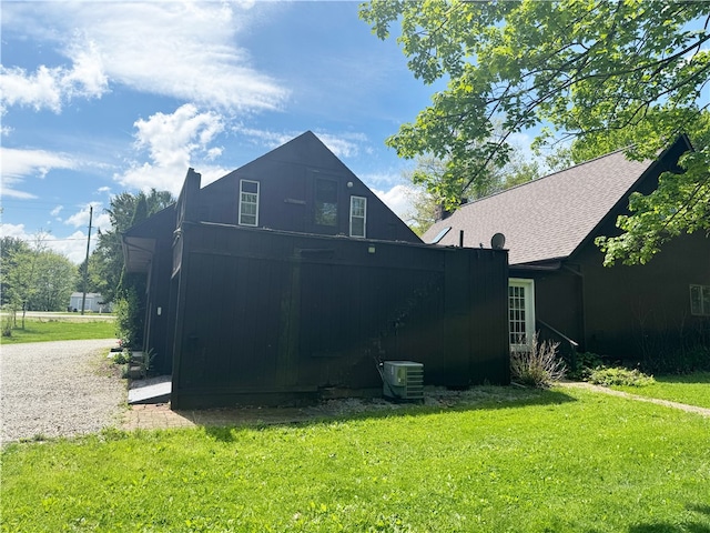 back of property featuring a yard and central air condition unit
