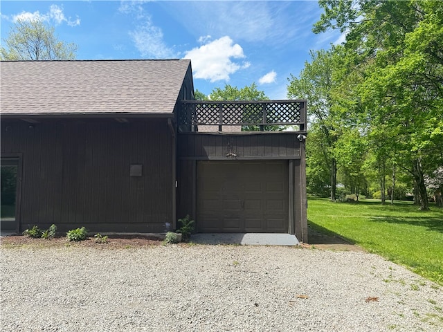 view of property exterior featuring roof with shingles, a garage, a lawn, and driveway