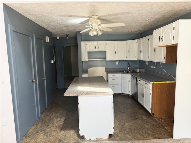 kitchen featuring stainless steel dishwasher, a kitchen island, white cabinetry, a ceiling fan, and a textured ceiling