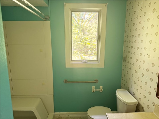 bathroom with toilet and baseboards