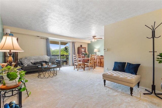 carpeted living area with a textured ceiling and ceiling fan