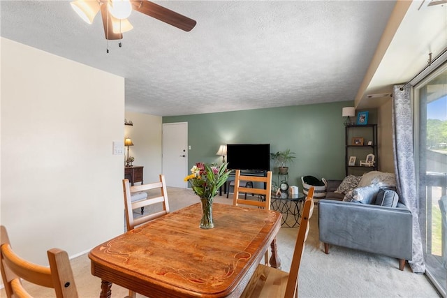 carpeted dining area featuring a textured ceiling and ceiling fan