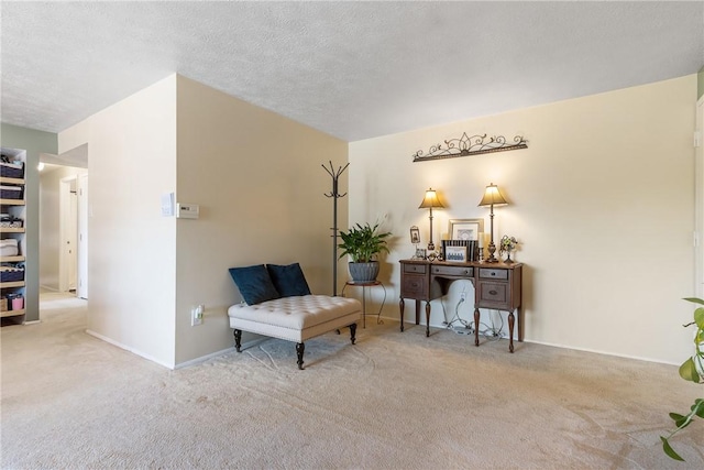 living area featuring carpet, baseboards, and a textured ceiling