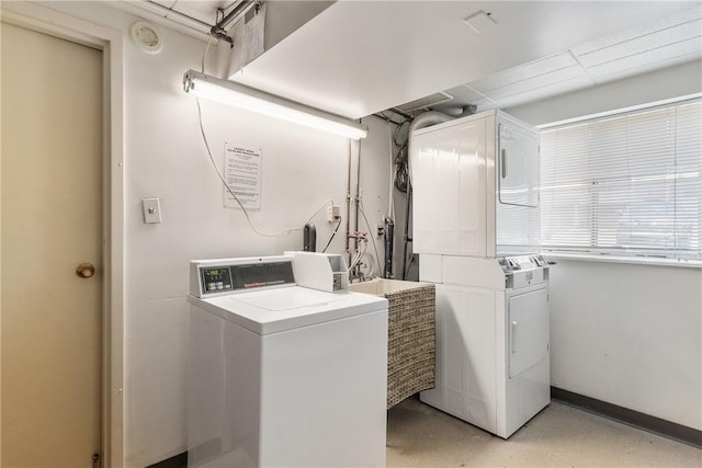 communal laundry room with separate washer and dryer and baseboards