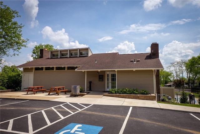view of building exterior featuring fence and uncovered parking