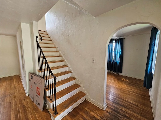 256 Duff Rd, Penn Hills, PA 15235 - stairs featuring hardwood / wood-style flooring, arched walkways, and baseboards