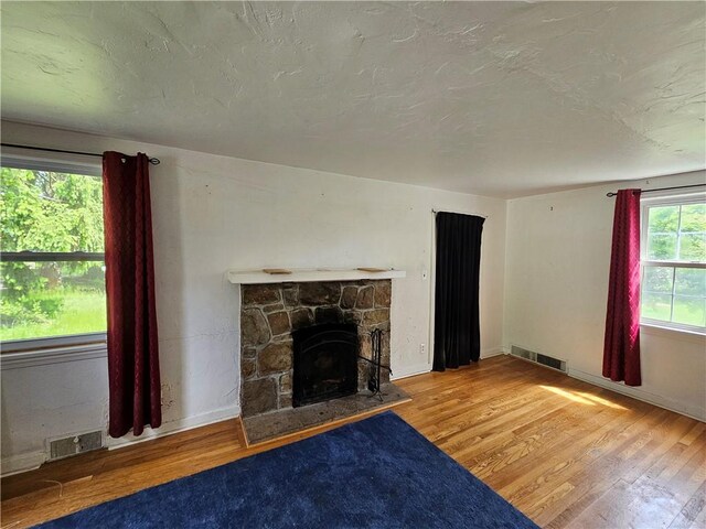 256 Duff Rd, Penn Hills, PA 15235 - unfurnished living room featuring wood finished floors, a fireplace, baseboards, and a textured ceiling
