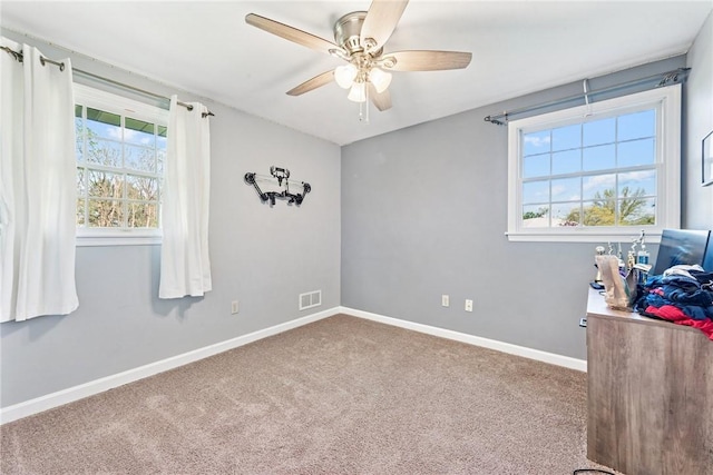 unfurnished bedroom featuring carpet flooring, baseboards, and a ceiling fan